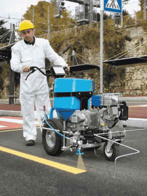Máquina de señalización vial aplicando marcas en carretera con sistema de pintura industrial